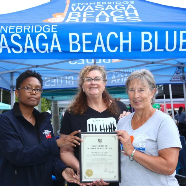 A representative of Brian Saunderson - MPP for Simcoe-Grey | Ontario's Minister of Sport, presents Yvette Gauthier (Director of Marketing) and Kathy Mulgrew (Past Chair) a certificate acknowledging Stonebridge Wasaga Beach Blues as a Grant Recipient for 2026 from the Ministry of Tourism, Culture and Gaming.

The Experience Ontario program provides support for festivals and events with a tourism economic impact to motivate visitors to discover Ontario, connect people with local experiences, and increase tourism spending.

The festival was thrilled to be a recipient of the grant and truly appreciates the support.😎🌊

#bluesinthebeach #governmentofontario